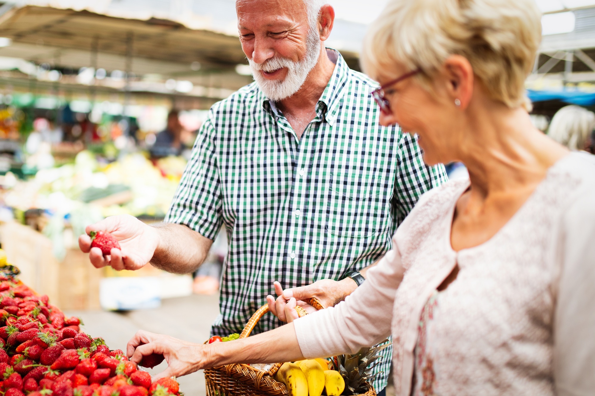 Senior family couple choosing bio food fruit and vegetable on the market during weekly shopping